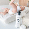 Oh Baby Liniment, fles van 400ml, met baby op verschoonkussen