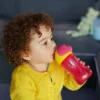 Baby met roze drinkbeker met rietje